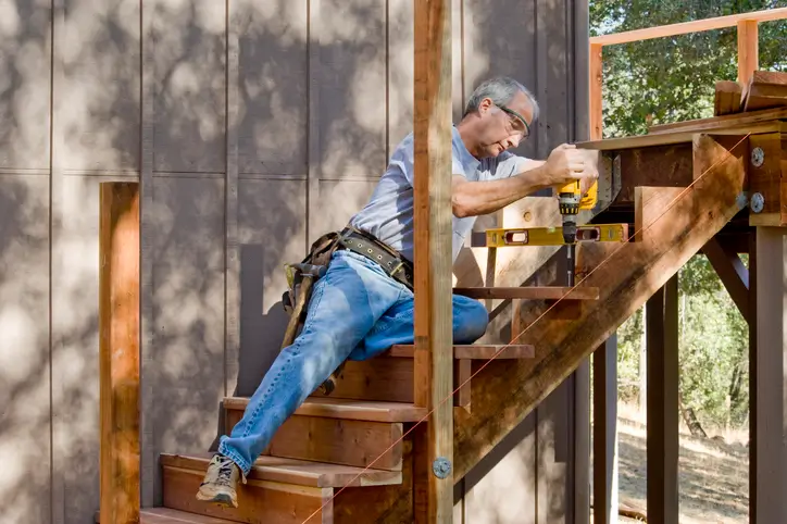 Carpenter installs a set of stairs leading to a deck in Maryland