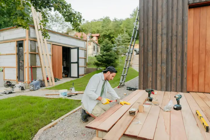 Five Star Deck Services carpenter installs wooden decking to the back of a Maryland house.