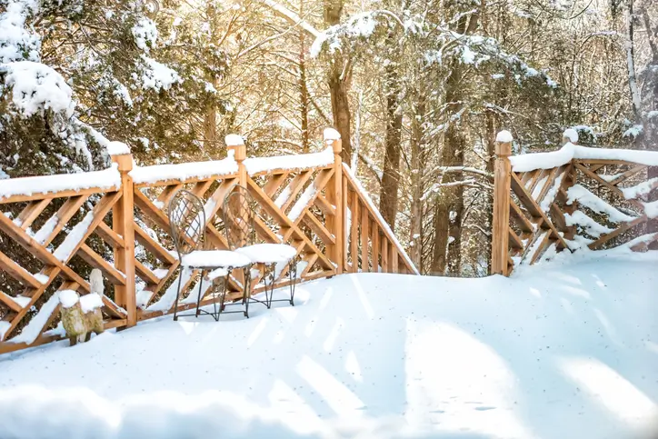 Snow covered wooden deck and railing on a Maryland home in the winter season