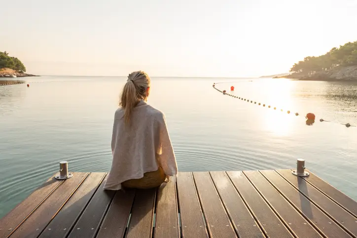 Woman sitting on a composite dock watching the sunset in Annapolis, MD